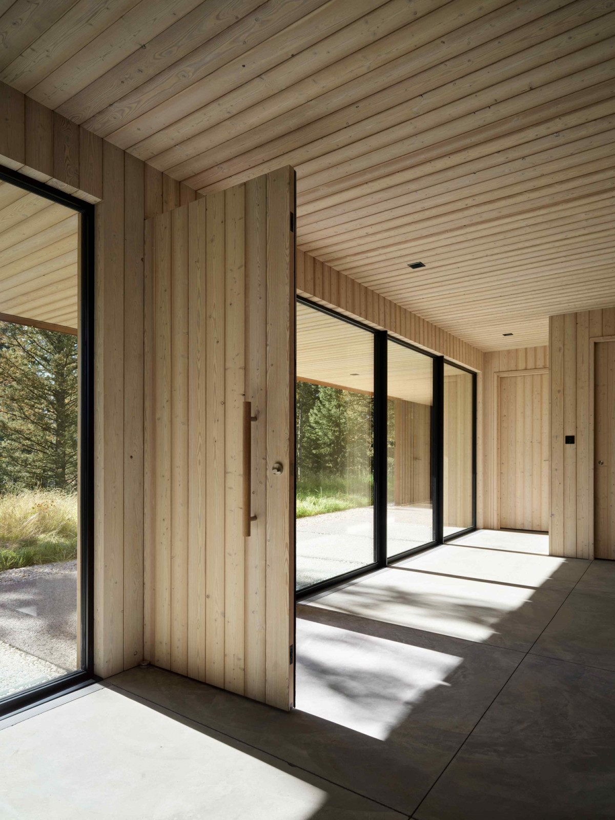 The cohesion between interior and exterior is anchored by the larch wood