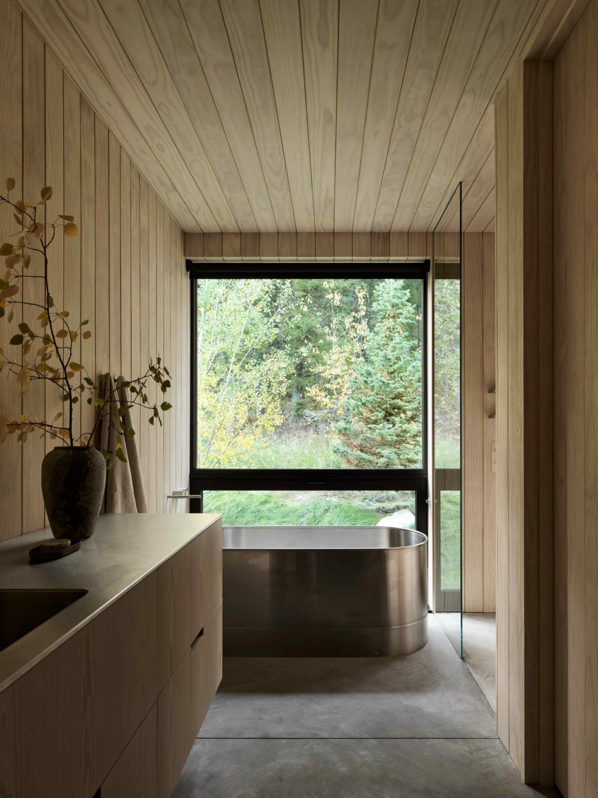 The bathroom reinforces the home’s cohesive materiality of larch wood