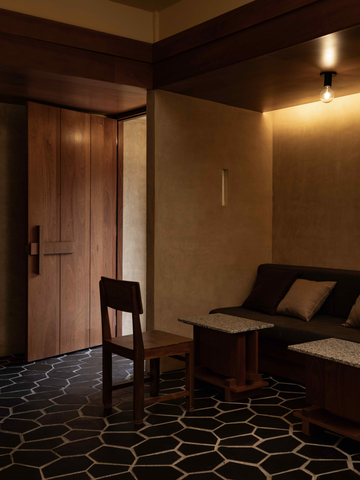 The interior is shaped by a palette of deep browns, muted greens, and layered textures (Photo: TWJPTO)