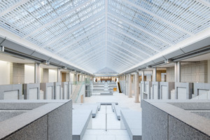The museum’s central atrium features a vaulted glass roof that filters natural light into the gallery spaces, with stepped platforms providing flexible seating and exhibition display areas  (Photo: courtesy of Yokohama Museum of Art)