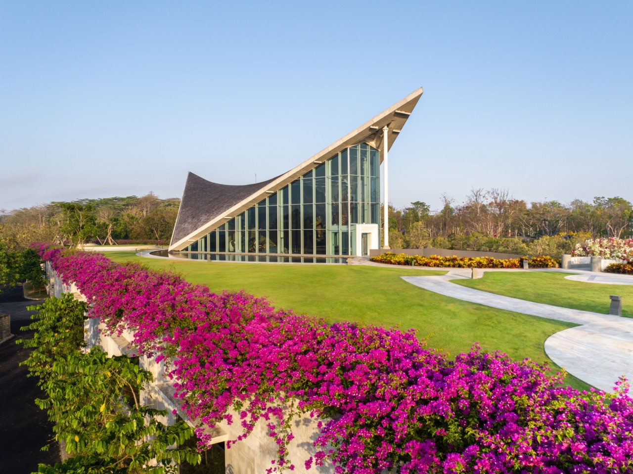 The museum’s primary facade features a sharply angled timber roof that extends beyond the glass curtain wall, providing shade and rain protection (Photo: courtesy of Saka Museum)