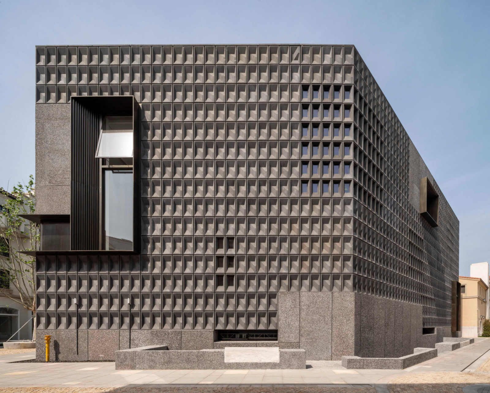 Deep-set windows create shadow patterns across the facade whilst reducing solar heat gain in the exhibition spaces (Photo: Pedro Pegenaute)
