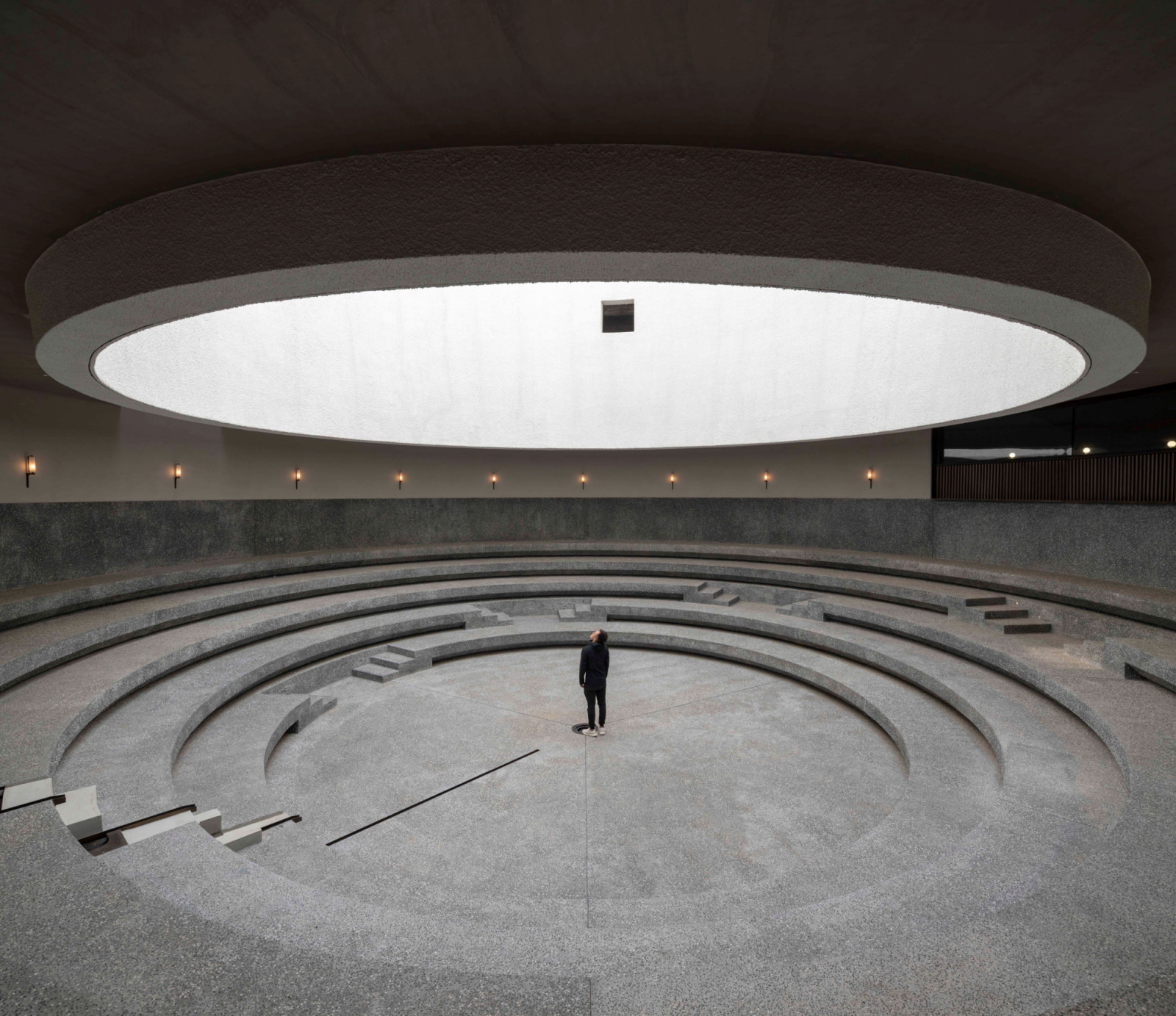 The central performance hall features concentric terraced seating that descends towards a circular stage (Photo: Pedro Pegenaute)