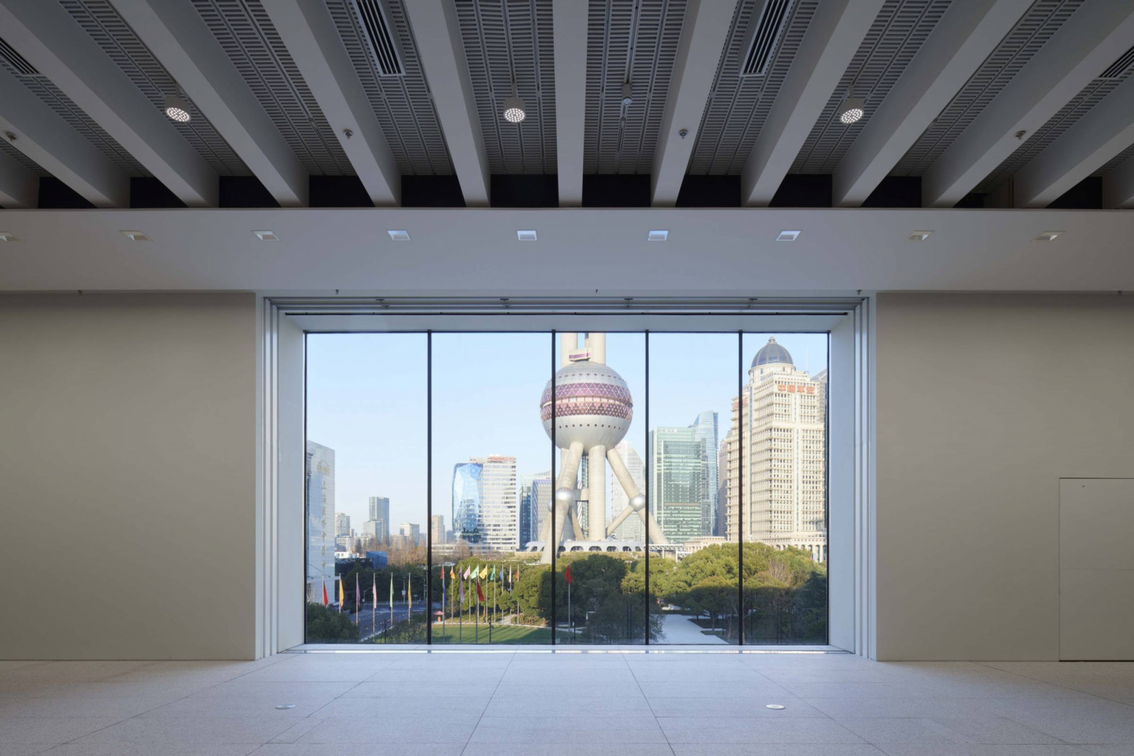 A first-floor gallery frames views of the Oriental Pearl Tower and surrounding skyscrapers through floor-to-ceiling glazing (Photo: Chen Hao)