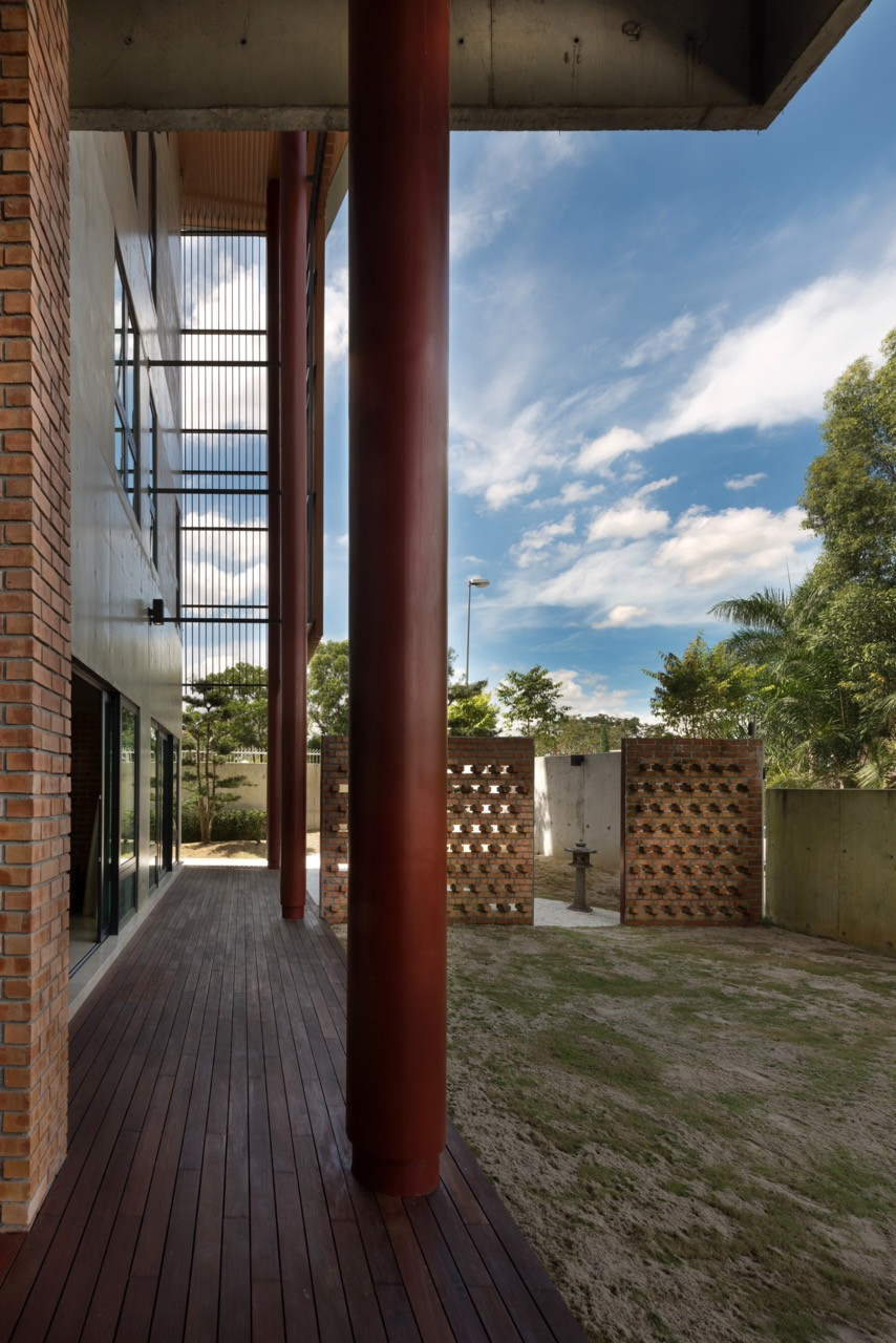 Perforated brick screen walls provide ventilation to the garden spaces beyond, whilst the exposed concrete structure remains visible overhead.