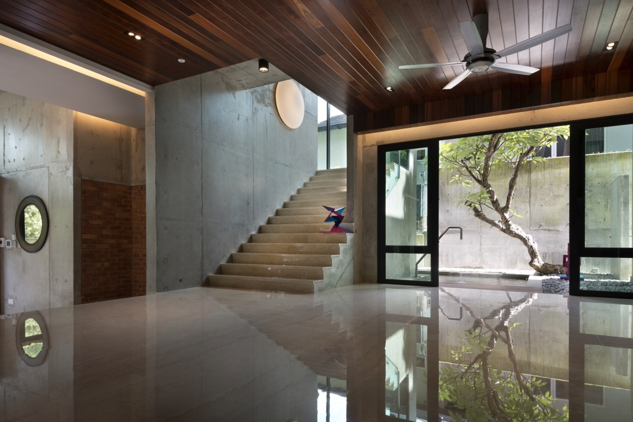 The marble staircase rises through the space whilst floor-to-ceiling glazing frames views of the Japanese garden and a mature tree within the internal courtyard