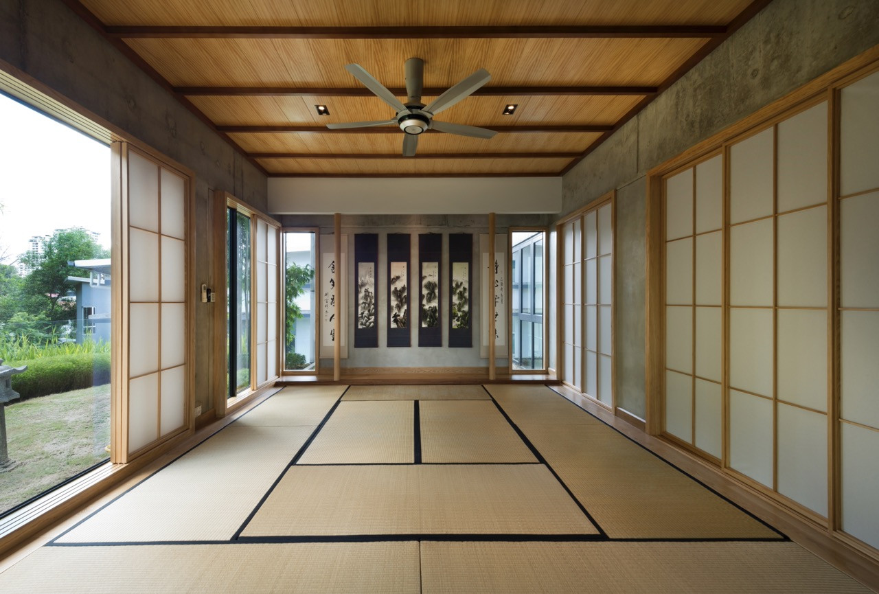 The Japanese-themed room, with tatami mat flooring and shoji screen walls, features a timber ceiling and opens onto views of the landscaped garden