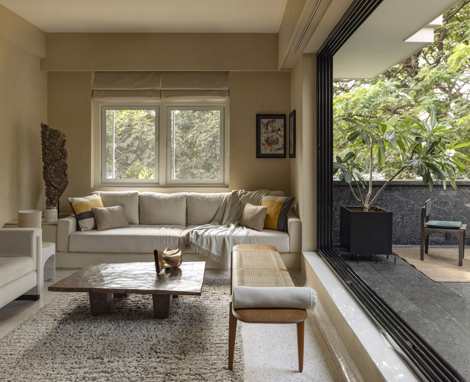 The living room and balcony of a renovated Art Deco home by Studio UF+O in Mumbai, India