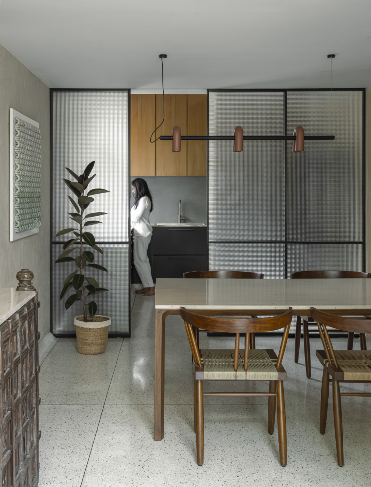 The kitchen and dining room of a renovated Art Deco home by Studio UF+O in Mumbai, India