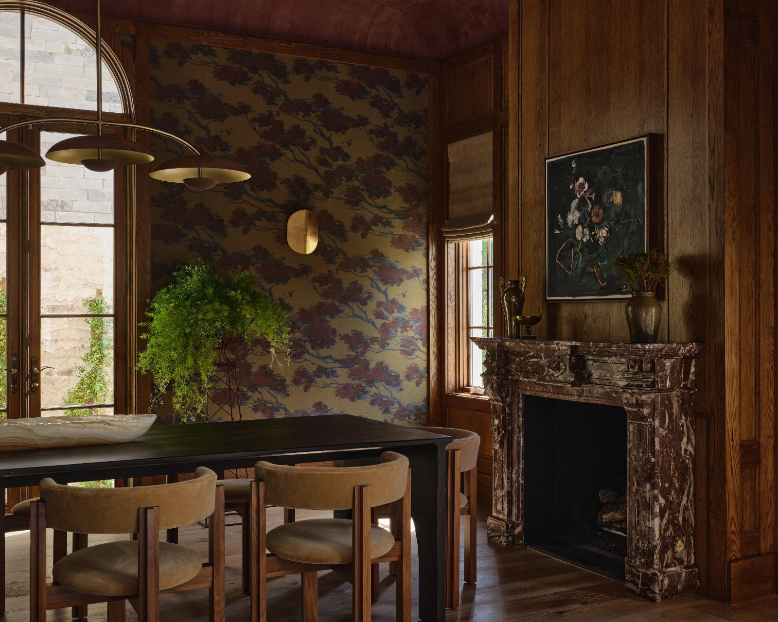 A moody, jewel-toned dining room with marble accents in a home designed by Shane & Pierce in Dallas, Texas