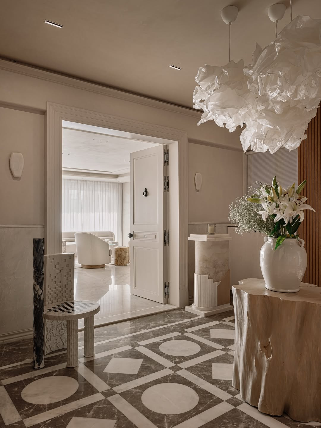 The spacious marble foyer greets in elegant hues of brown and beige