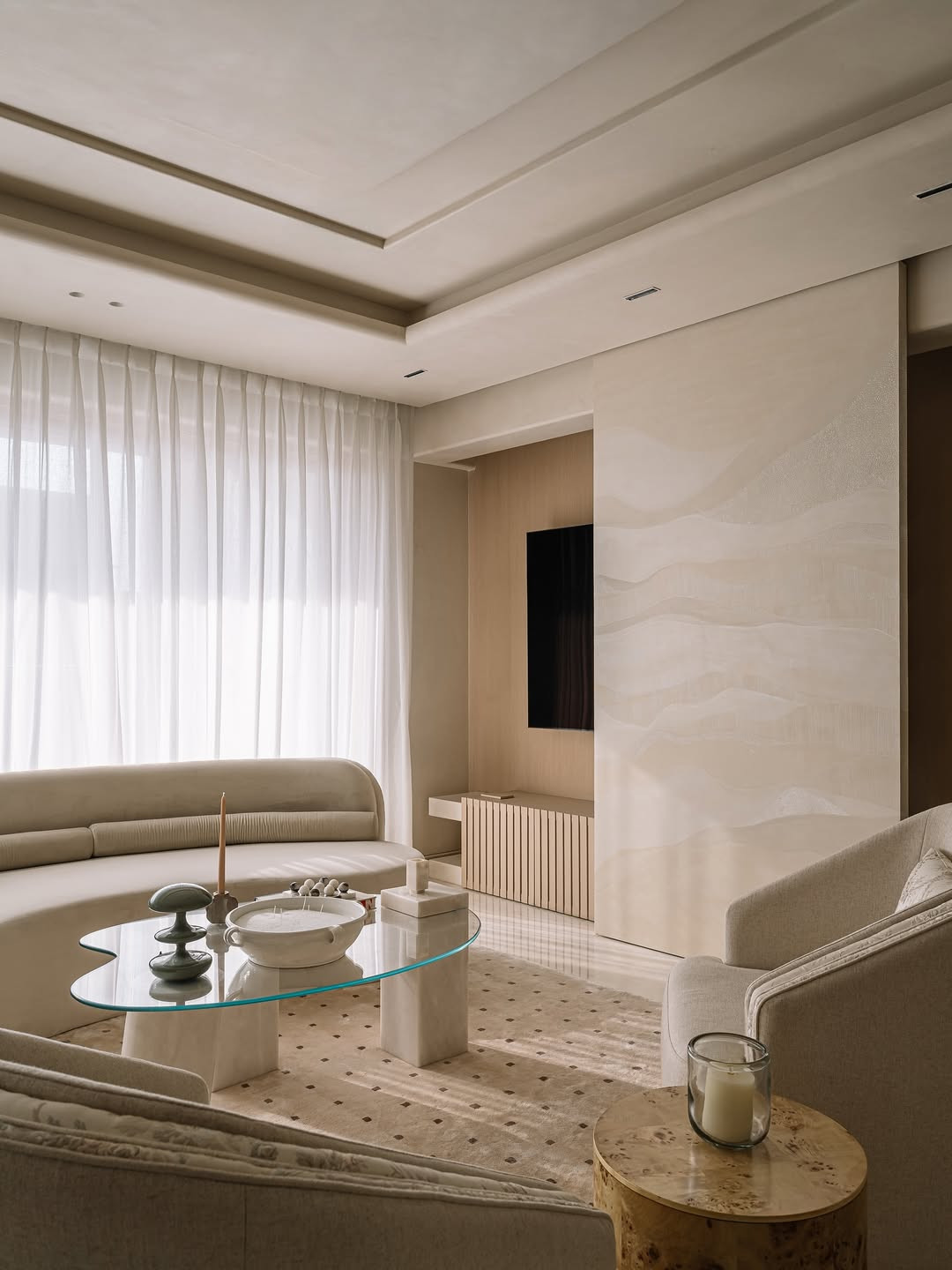 Pearl-toned marble underfoot and off-white stucco pilasters dominate the living room