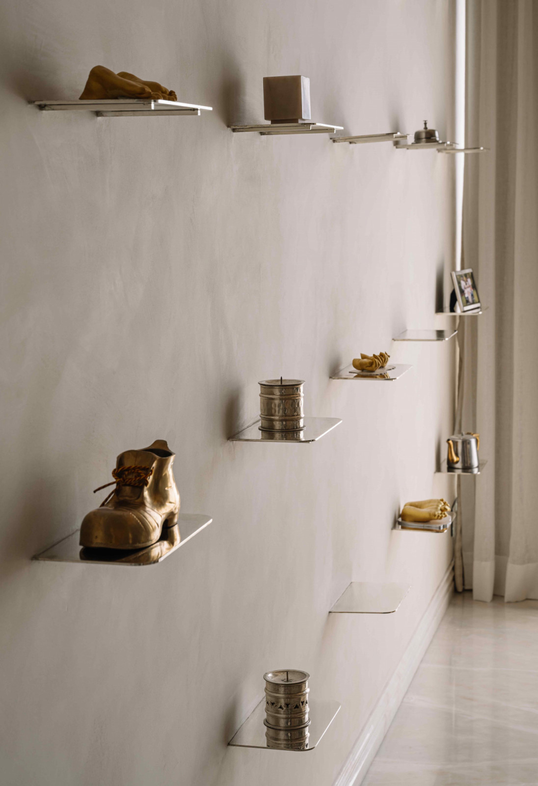 Metallic objects gleaming on a display wall with custom shelving