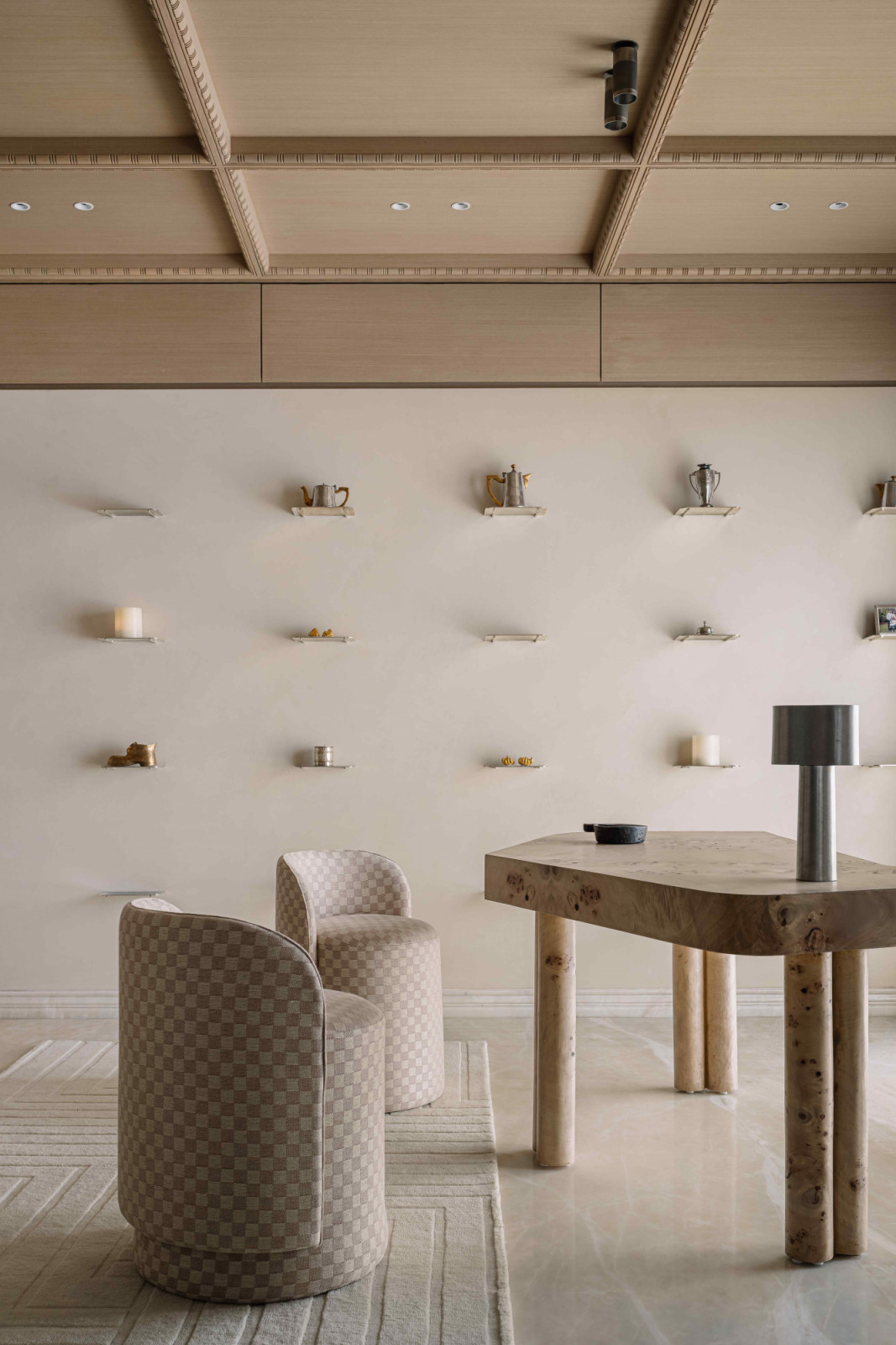 The asymmetrical table beneath a minimalist coffered ceiling