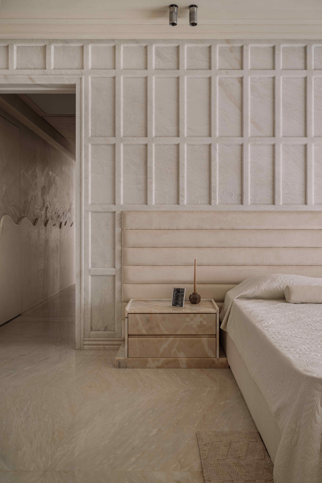 Neoclassical marble-panelled wall anchors the space, exuding quiet luxury