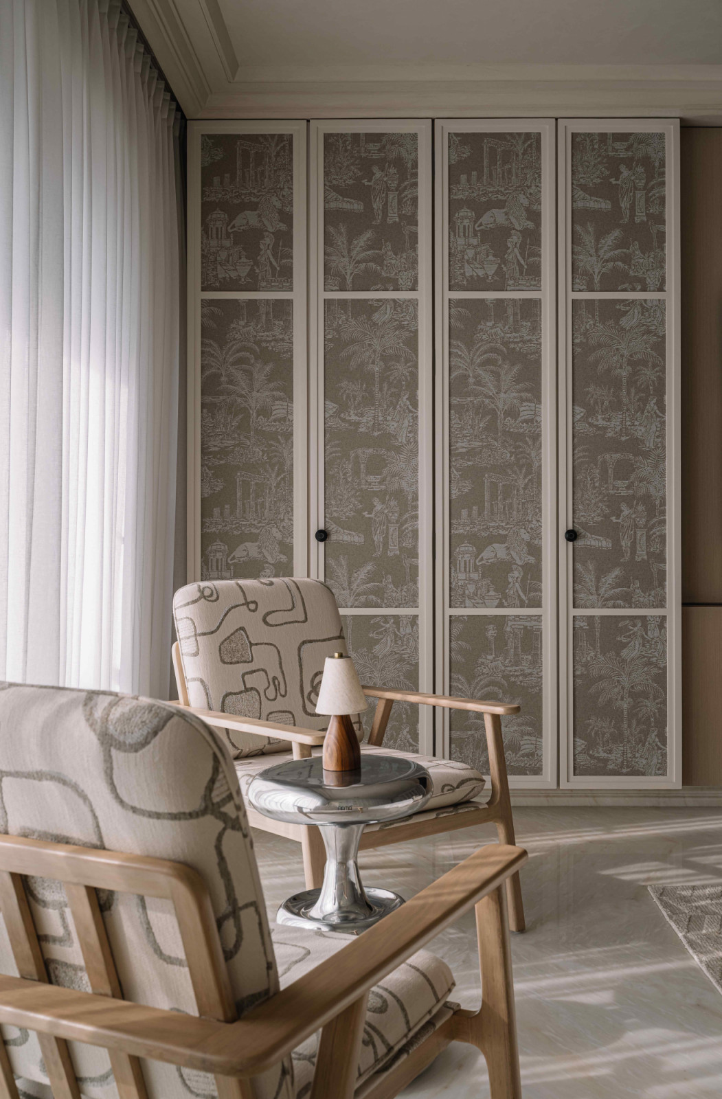 Classical foliage prints upon the shutters paired with twin accent chairs