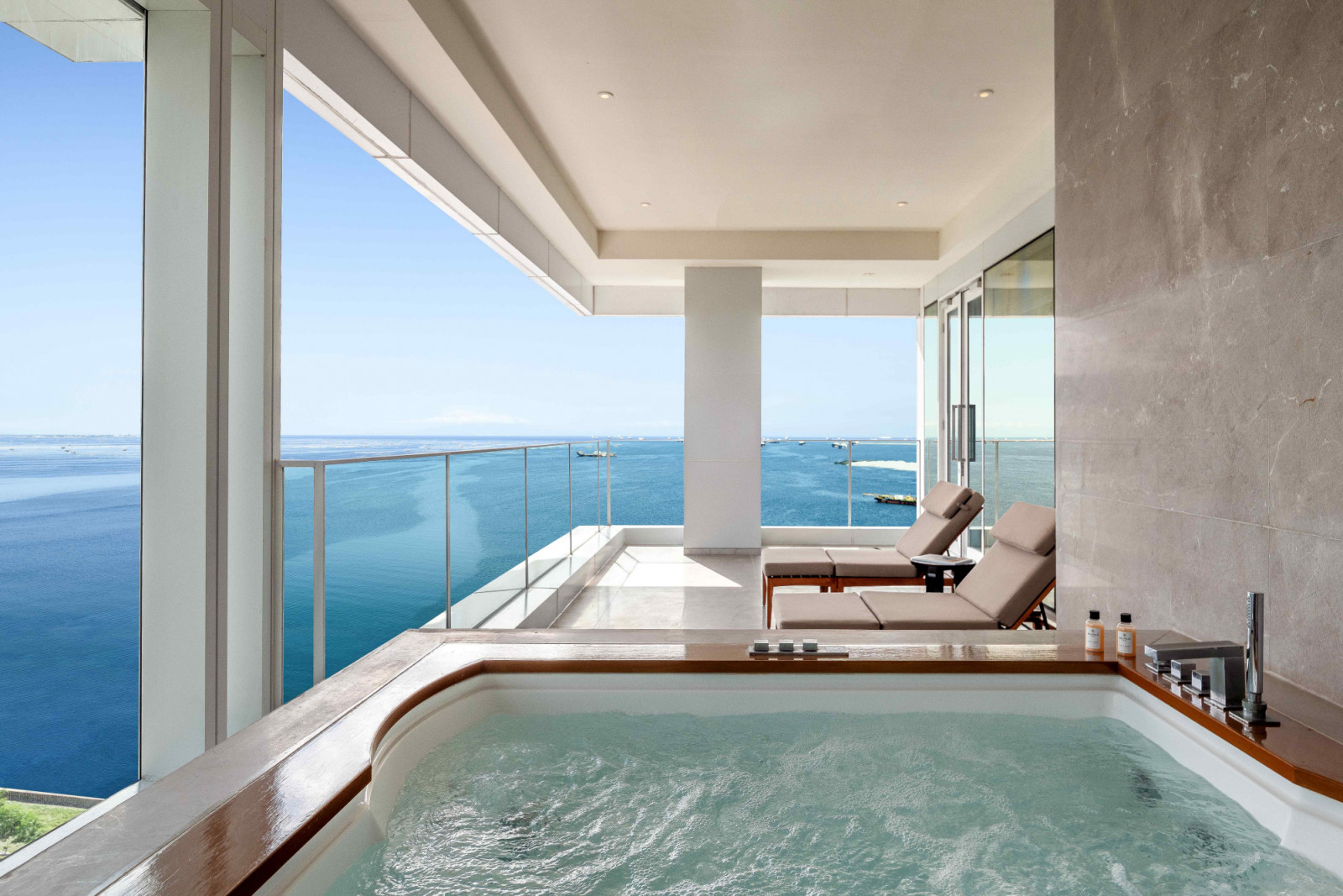 An outdoor deck with a private Jacuzzi and Manila Bay views