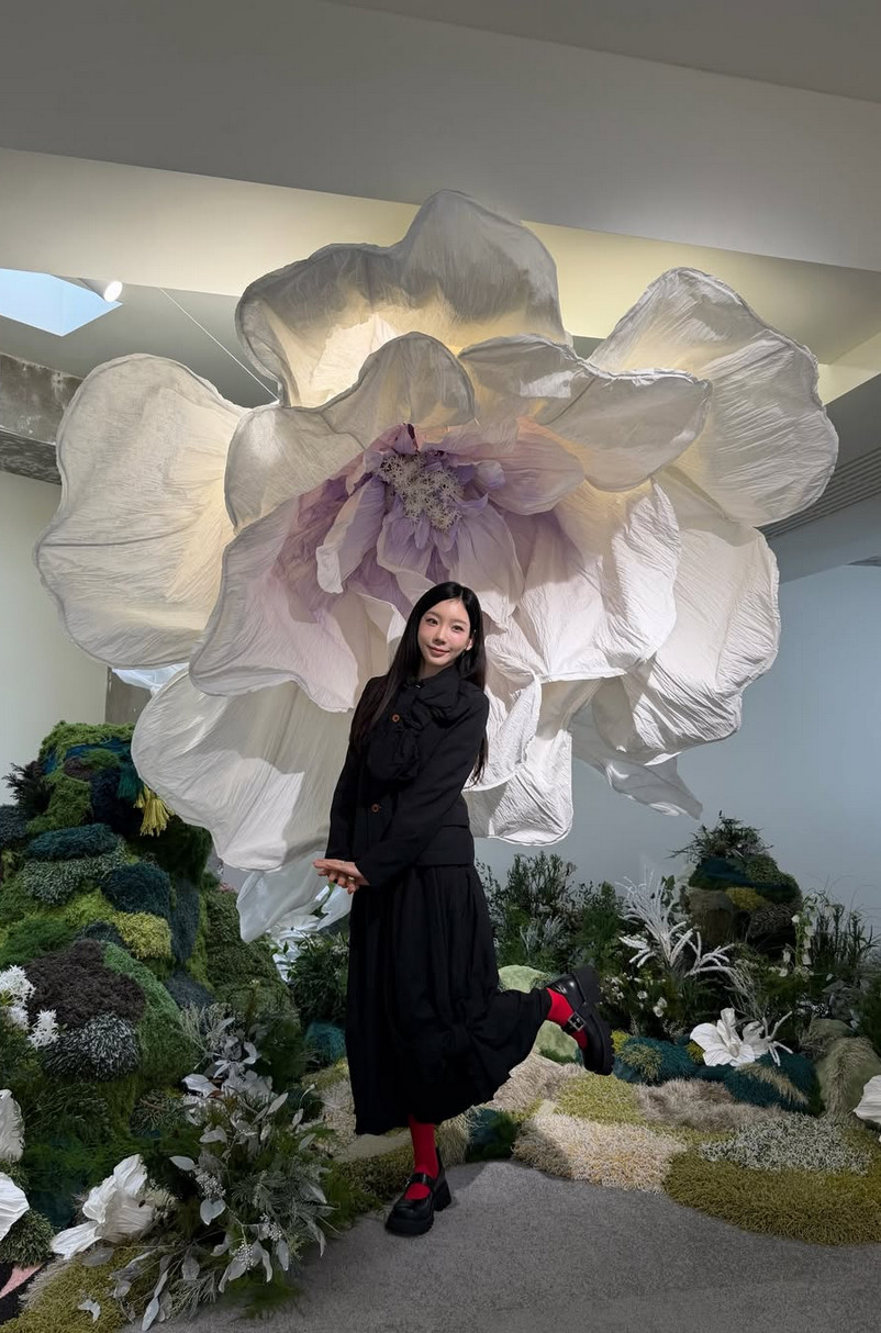 Taeyeon poses against a giant flower in gothic black tailoring for ‘Panorama’ exhibit (Photo: @taeyeon_ss / Instagram)