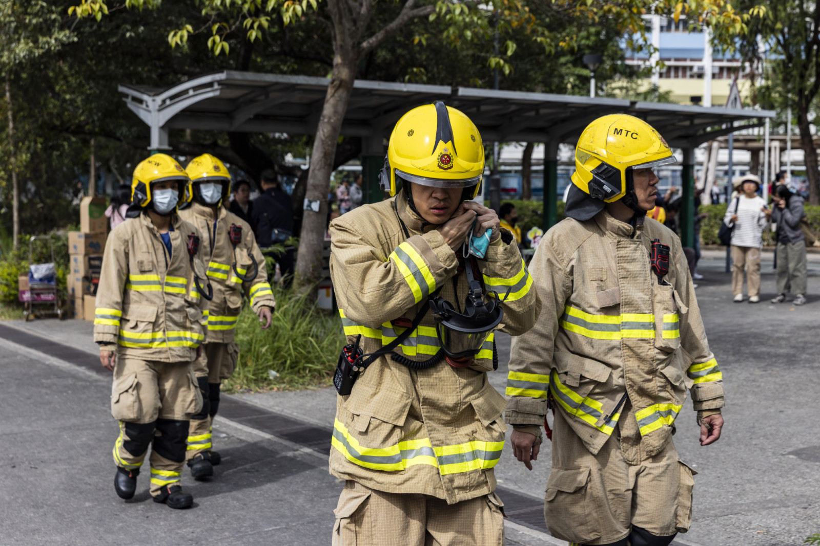 HONG KONG, CHINA - NOVEMBER 27: Firefighters walk near residential buildings that continue to burn at Wang Fuk Court in the Tai Po district on November 27, 2025 in Hong Kong, China. At least 44 people are dead and hundreds are missing following a high-rise apartment fire at Wang Fuk Court in Hong Kong's Tai Po district. Authorities have detained three individuals for questioning as investigators examine the cause of the blaze. (Photo by Isaac Lawrence/Getty Images)