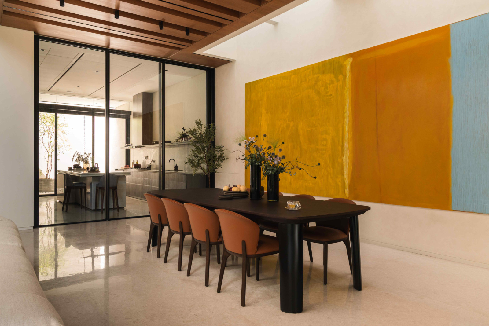 The adjacent dining area with a striking abstract artwork in vivid hues of yellow, blue, and orange