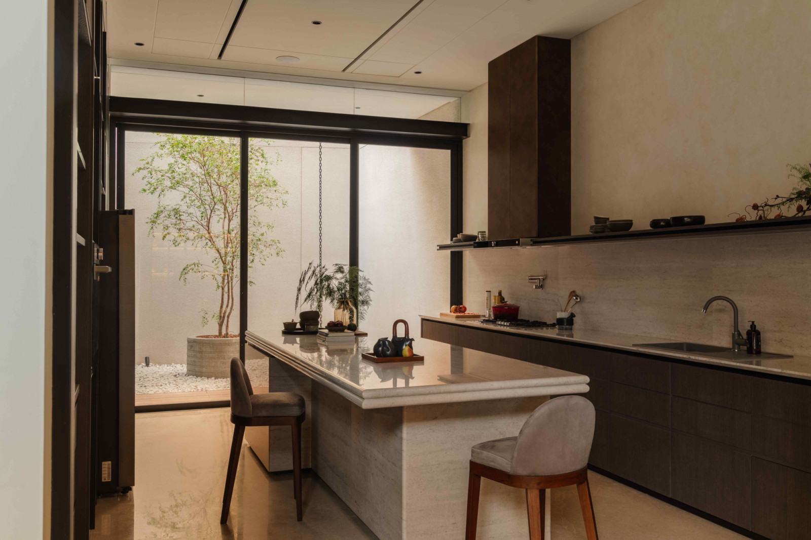 In the pantry, the sleek white marble countertops with dramatic veining encourage casual gatherings