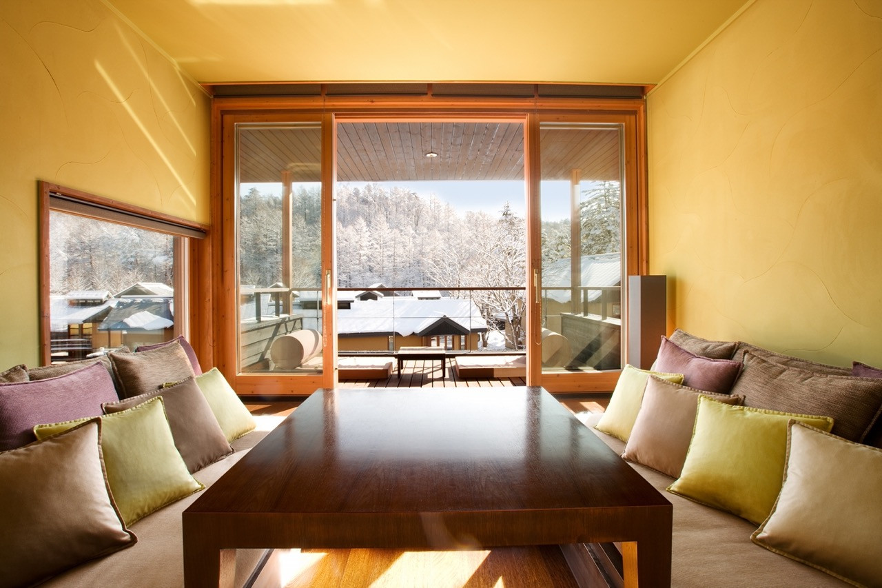 Morning light arrives in the sitting area first in the Mizunami room type, with the architecture tracking solar movement passively throughout the day