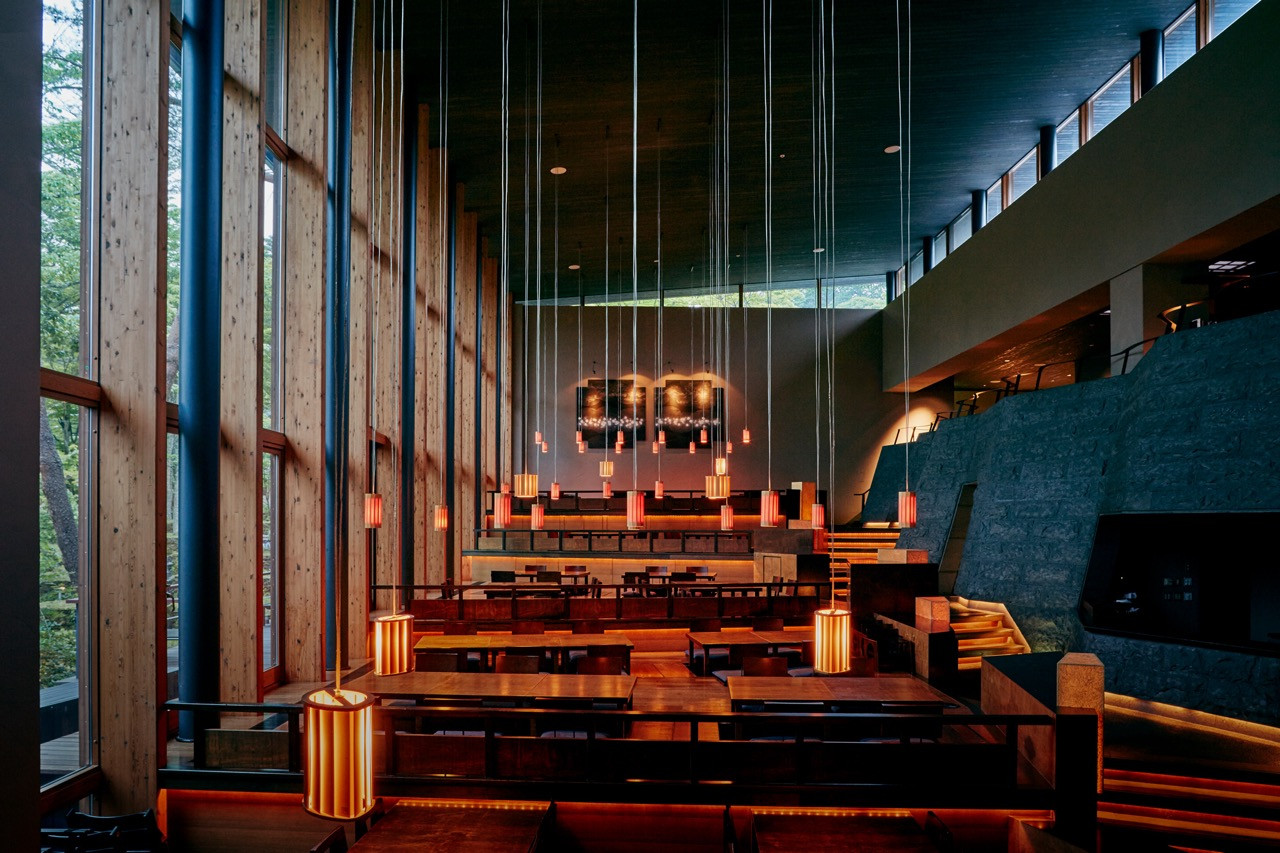 Service spaces recede into the background at the dining pavilion, with the lighting design transforming the space after sunset through careful withdrawal of artificial light