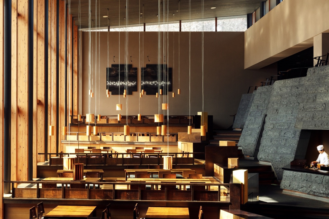Wood joinery and material honesty define the dining pavilion, where stone, timber, and glass create a space for the valley beyond to register as primary content
