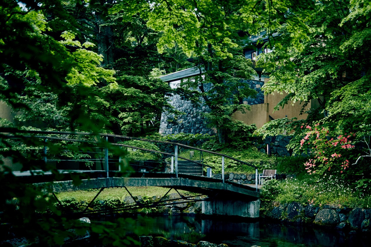 The property's network of winding paths connects pavilions while preserving the shape of the valley and its existing trails