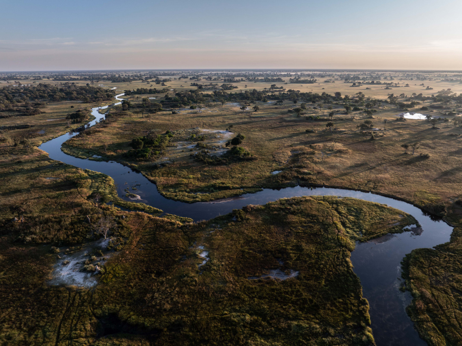 Pemandangan udara dari alur sungai berkelok di Cekungan Sungai Kwando di Botswana, yang mengalir menuju Sungai Zambezi. Lebih dari 20 juta orang di Afrika bagian selatan, serta tak terhitung spesies tumbuhan dan hewan, bergantung pada derasnya aliran Sungai Zambezi.