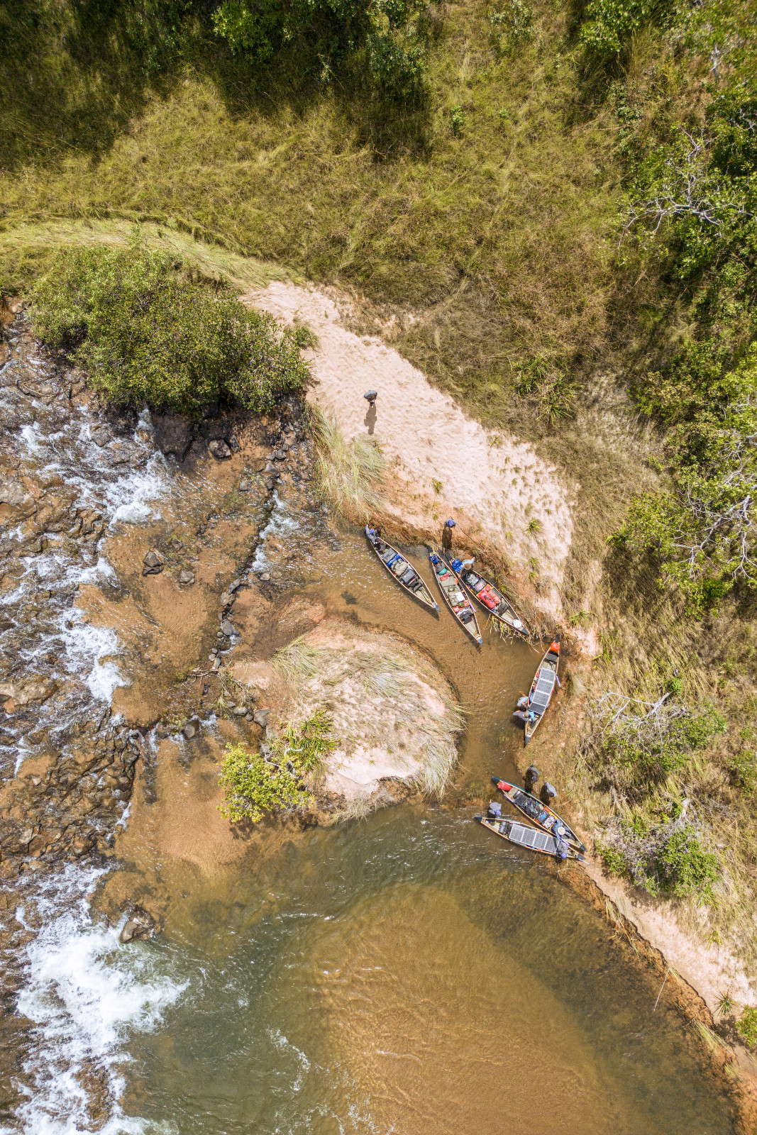 Tim ekspedisi Great Spine of Africa mendekati jeram yang kuat saat melakukan perjalanan menyusuri Sungai Cassai. Penting untuk berhenti dan menilai rute terbaik untuk menavigasi perairan berbatu tersebut sebelum melanjutkan perjalanan dengan kano khusus mereka.