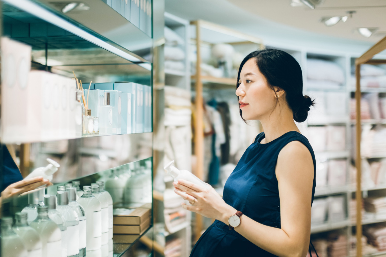 Beautiful pregnant woman shopping for beauty products in shopping mall