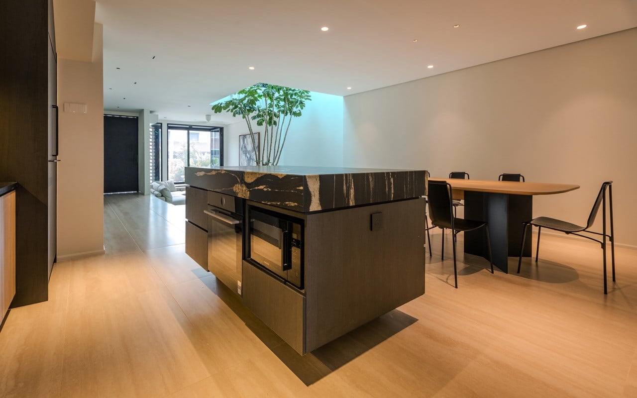 The kitchen island features Brazilian quartz granite from Stone De Art with the central lightwell visible beyond
