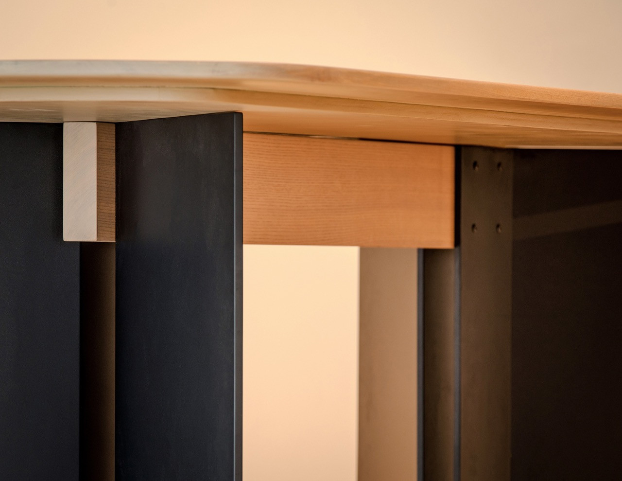 Detail of the dining table showing the recessed skirting that creates the “floating mass” effect, allowing the table to appear gently lifted from the ground