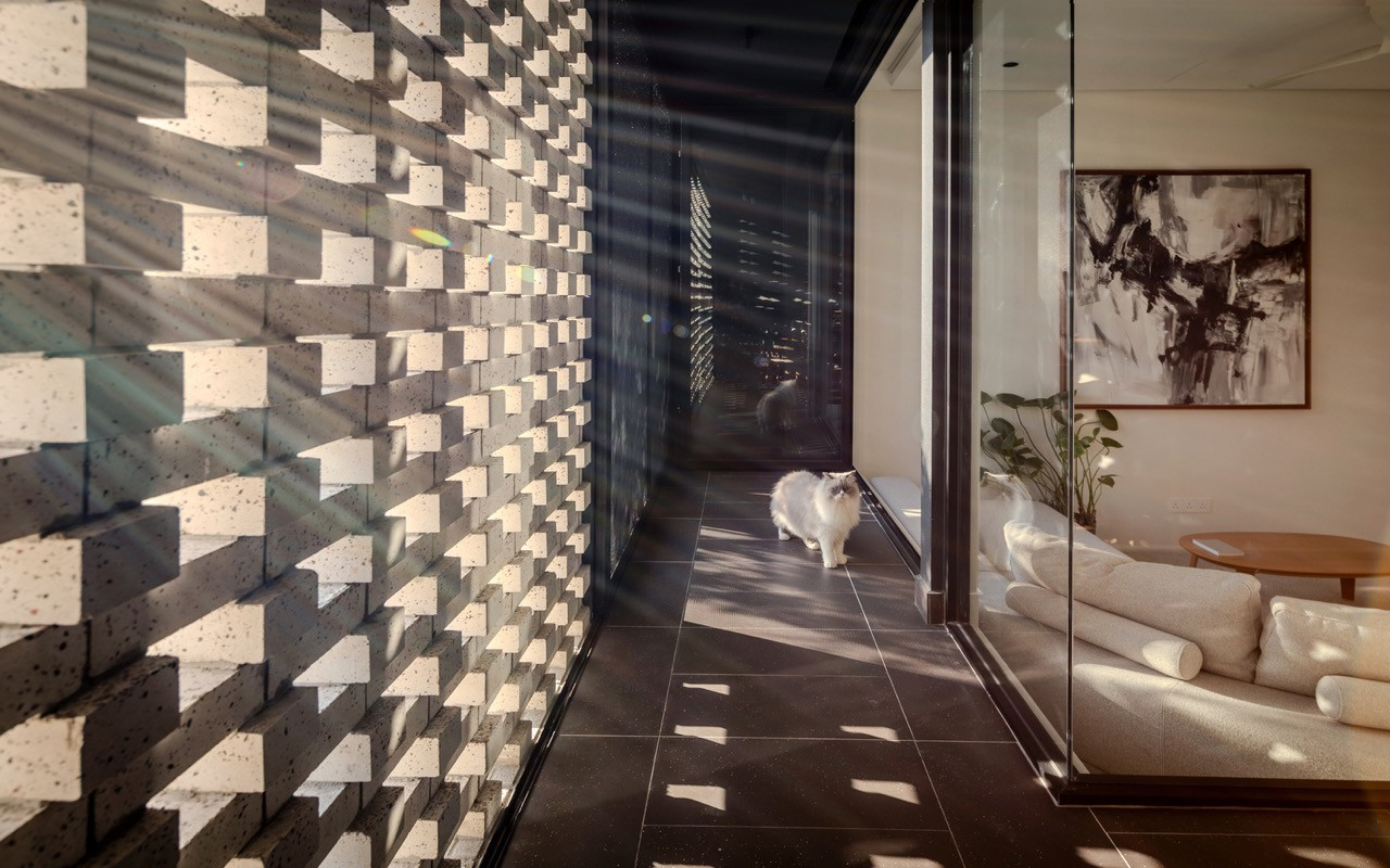 The terrazzo-like custom bricks, the first of their kind used in Malaysia according to supplier Saujana Stone, form a double-skin system that moderates heat gain
