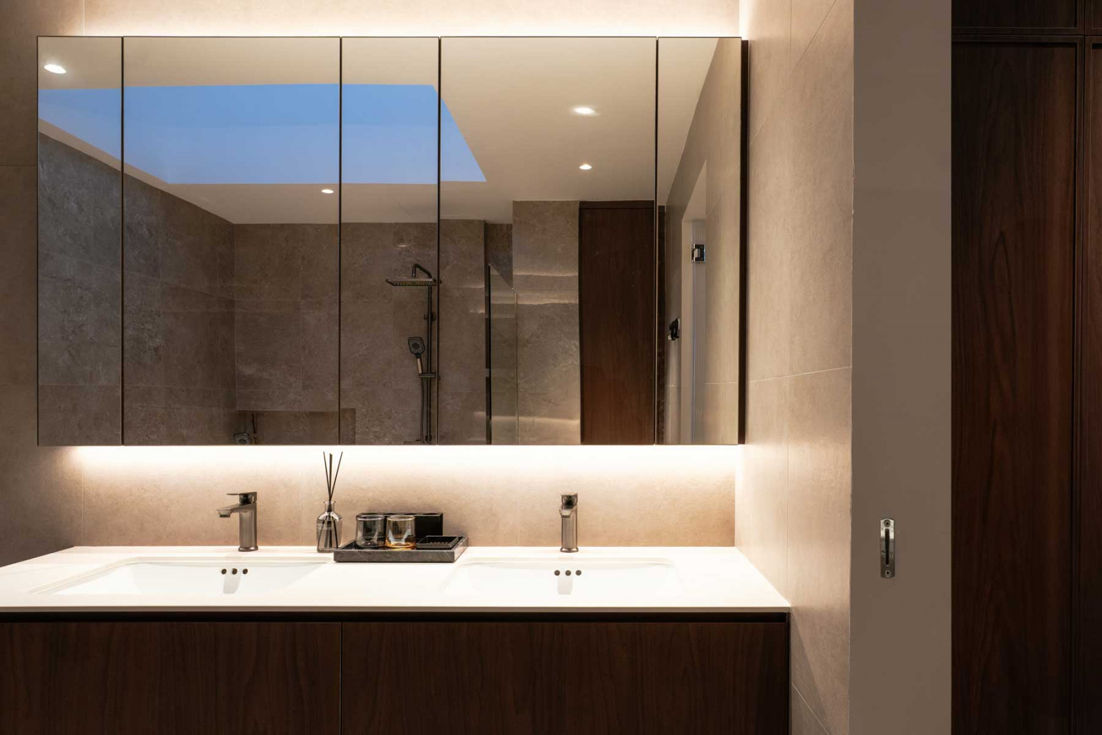 Bathrooms are designed with soft, corner lighting and textured finishes to create a crafted, luxurious experience
