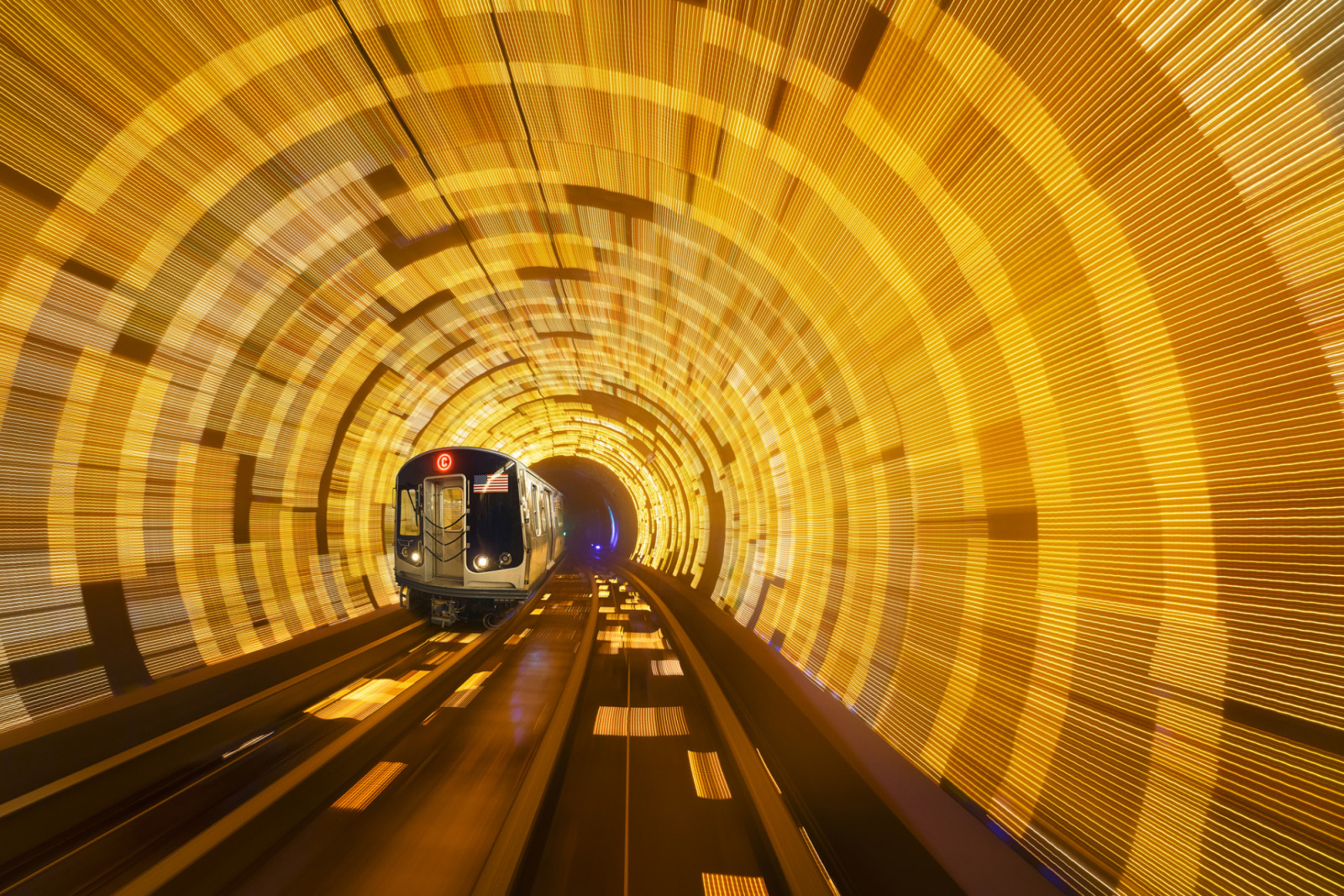 Subway Train in Motion at C Eighth Avenue Local. Speeding Train in New York City Subway Subway railroad tracks. Subway train passes in a motion blur tunnel at C Eighth Avenue Local. NYC, New York, USA (ภาพ: Juan Maria Coy Vergara / Getty Images)
