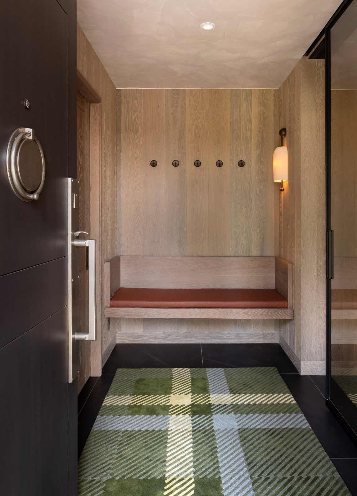 Balancing materiality and playful plaid patterns at a renovated ski chalet in Quebec, Canada, designed by ACDO