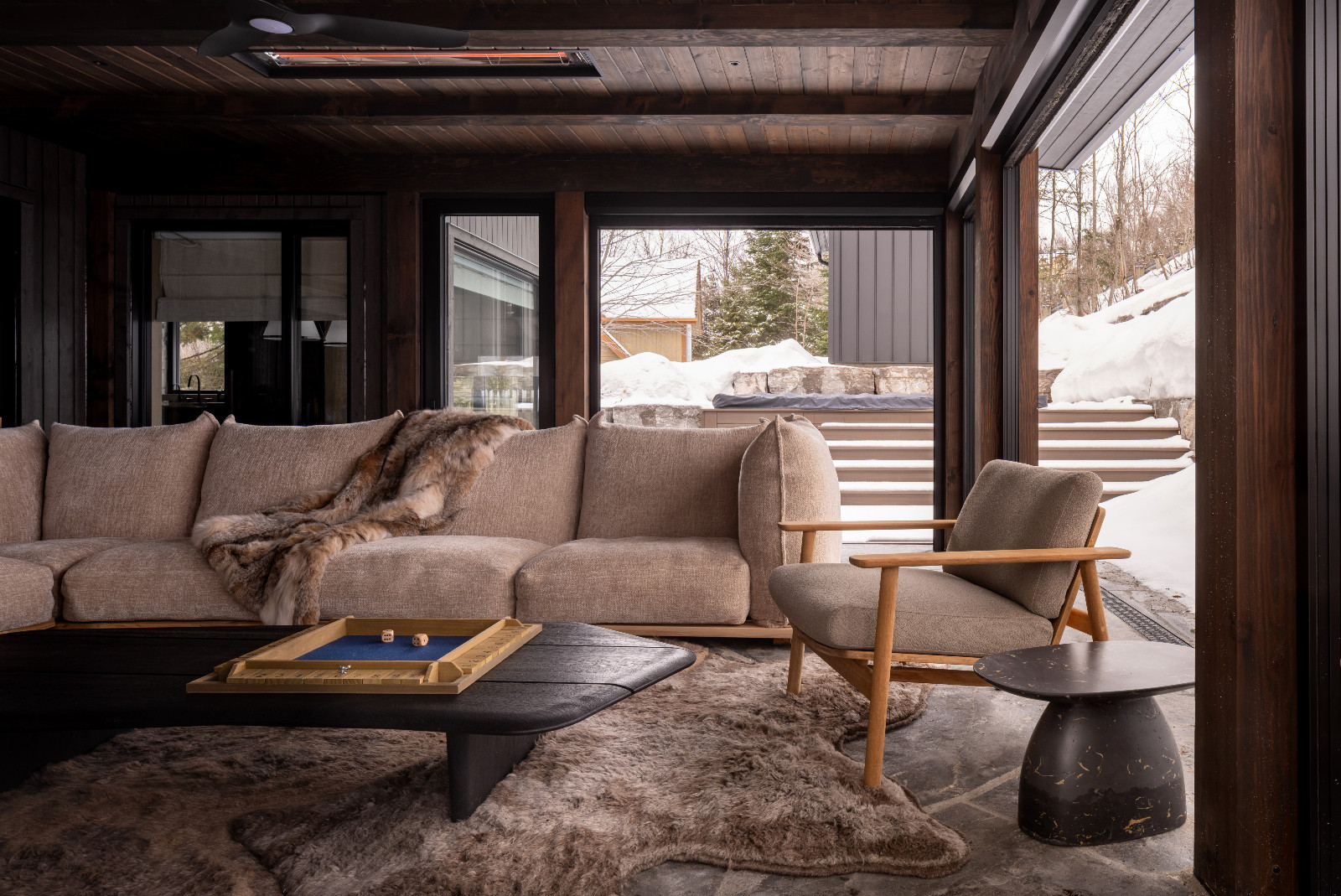 The outdoor patio area of a renovated ski chalet in Quebec, Canada, designed by ACDO