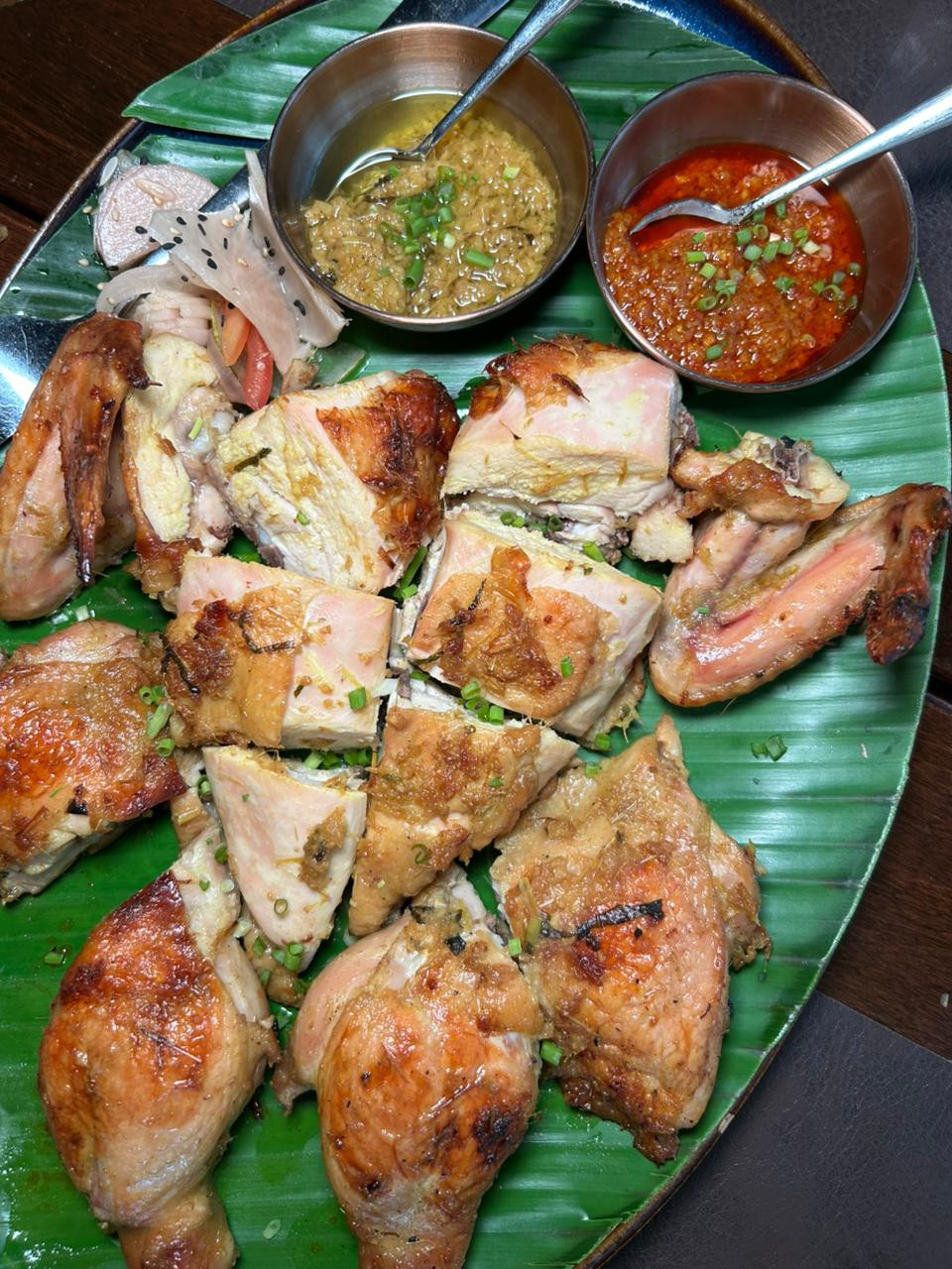 A whole roasted ginger chicken is served golden and juicy, with exceptional spicy sambal and ginger-scallion sauce to enhance the experience at The Pearl Room | Photo: Jaclyn Koppe