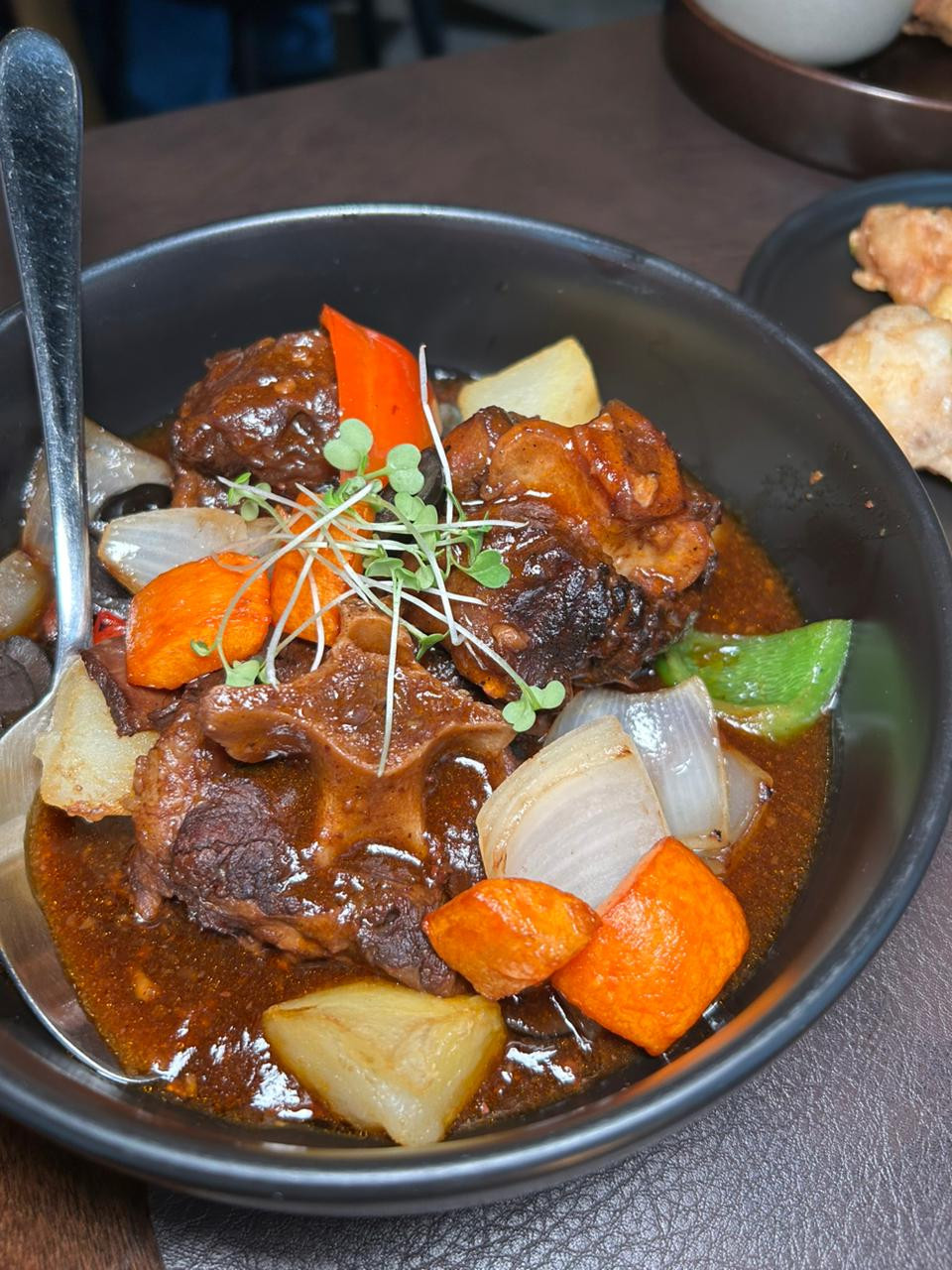 Slow-cooked oxtail in spicy tomato sauce- braised skinless oxtail in a rich red sauce, flavoured with peppers, onion, and black olives by The Pearl Room | Photo: Jaclyn Koppe