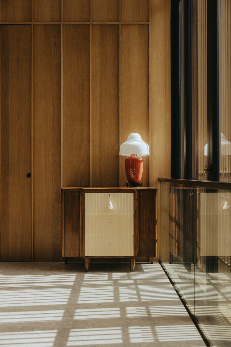 A corner that flaunts the harmonious combination of architectural finish and furniture pieces, enriched by the shadow cast by the birdcage-inspired facade