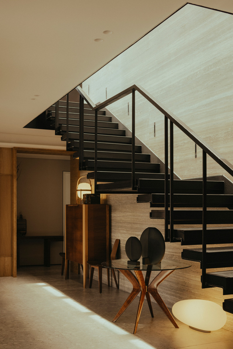 displayed beneath the staircase, the furniture and homewares with curvy details soften the architectural lines of the house