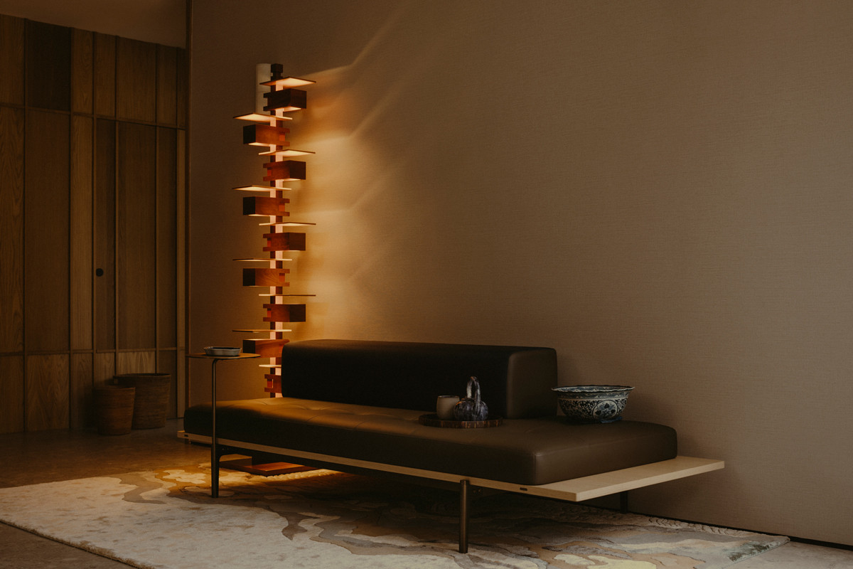 The Taliesin 2 floor lamp from Yamagiwa, another Frank Lloyd Wright creation, is paired with the half-back Discipline sofa from Stellar Works in this moody corner