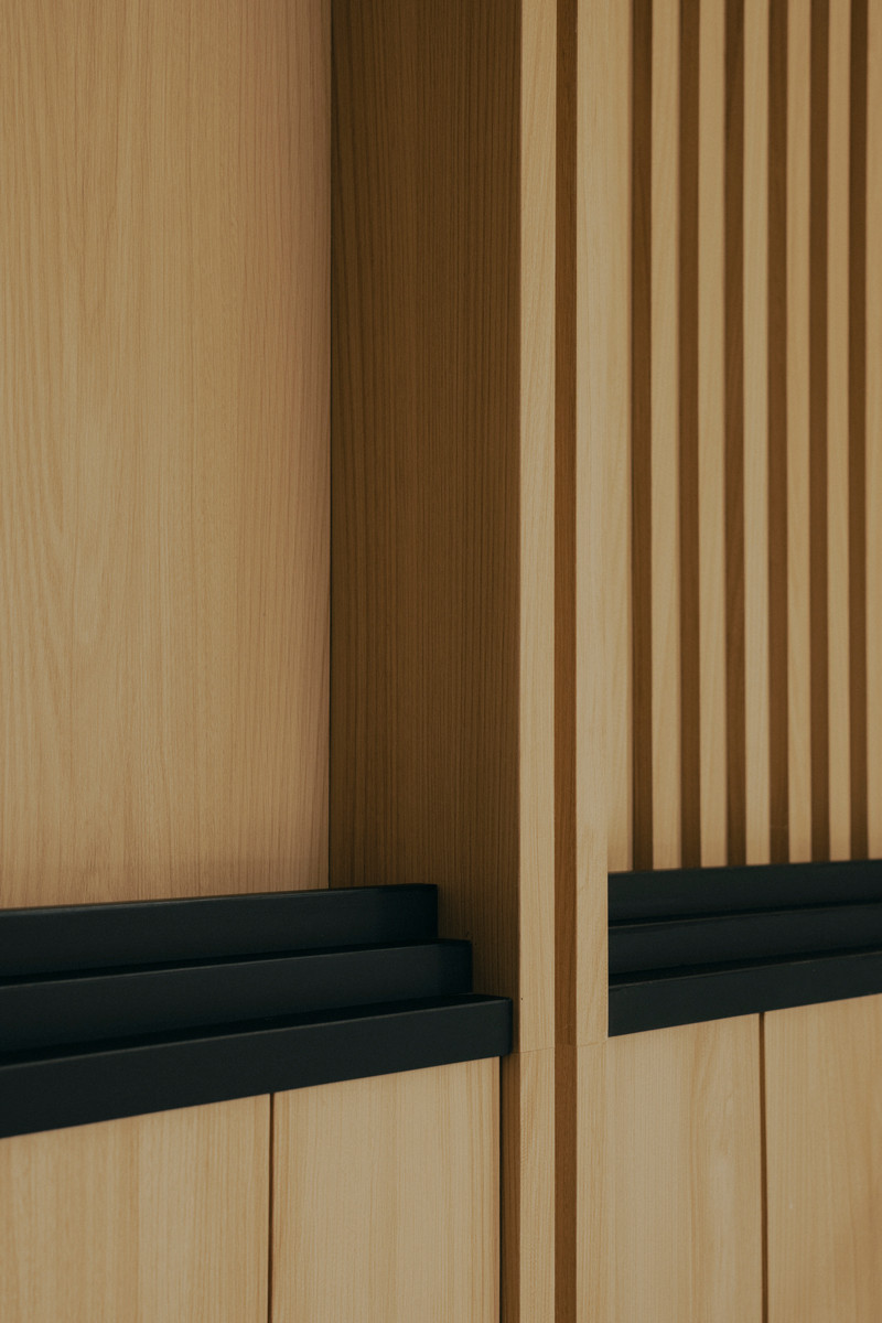 A close-up detail of the Good Class Bungalow’s wall, beautifully articulated with contrasting wood finishes