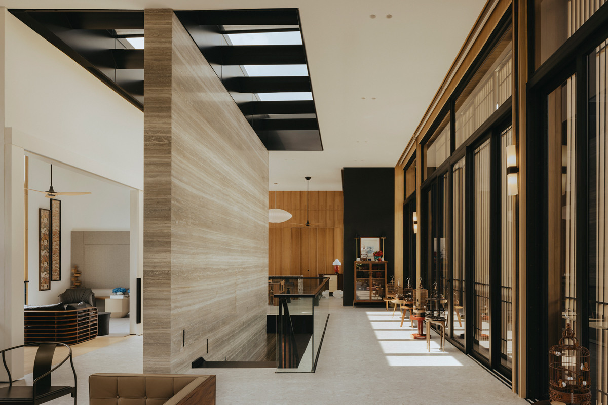 The light-toned timber facade provides a dynamic counterpoint to the dark finishes of the Good Class Bungalow’s interior