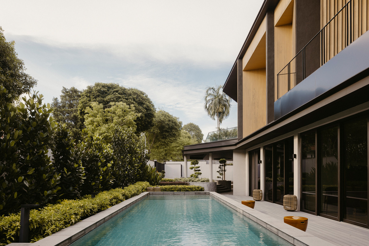By the blue pool, the timber-screened façade stands in the background, its details echoing the home’s Asian heritage