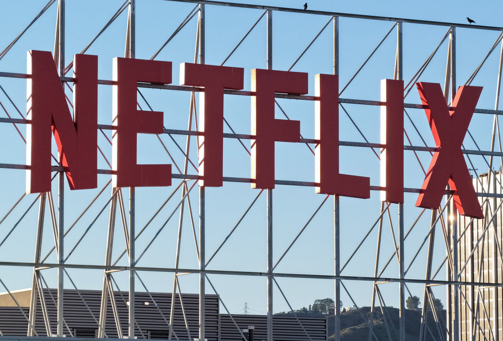 LOS ANGELES, CALIFORNIA - DECEMBER 05: In an aerial view, the Netflix logo is displayed above Netflix corporate offices on December 5, 2025 in Los Angeles, California. Netflix and Warner Bros. Discovery, Inc. have announced an $82.7 billion deal for Netflix to acquire Warner Bros. film and TV studios, HBO Max, and HBO. (Photo by Mario Tama/Getty Images)
