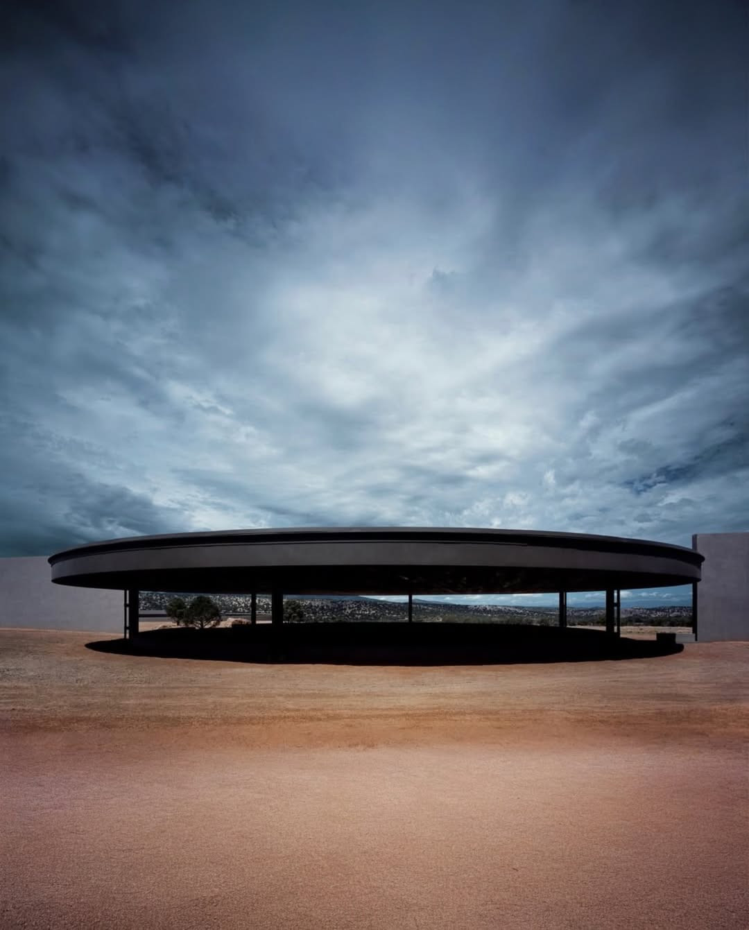 The indoor arena, partially recessed into the land, frames the horizon through low, linear openings (Photo: Instagram / @architectanddesign)