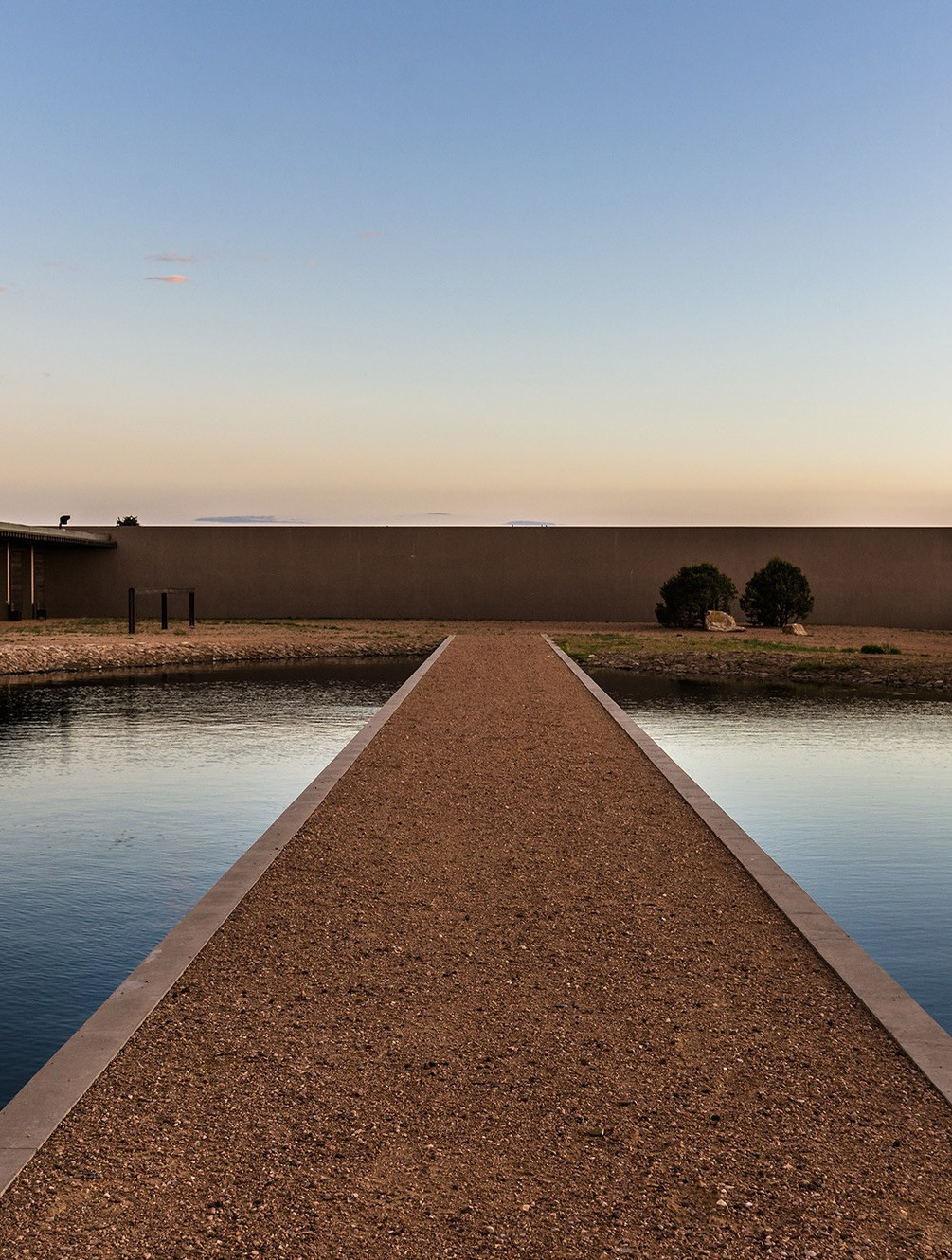 A gravel gangway appears to float across the reflecting pool (Photo: Instagram / @kellybehunstudio)